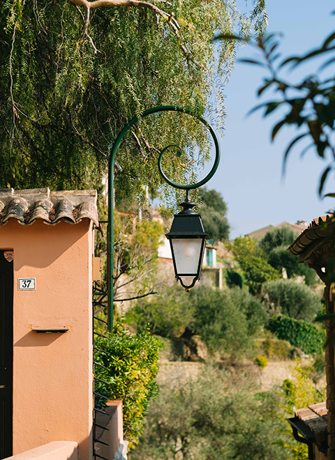 Vue d'un lampadaire accroché au mur d'une maison avec le village en arrière-plan.